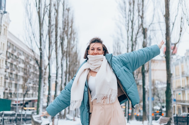 Free photo happy woman in winter on snowy city alley