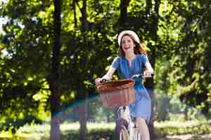 Free photo happy woman with bike in forest
