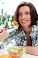 Foto gratuita donna felice con la ciotola di insalata fresca