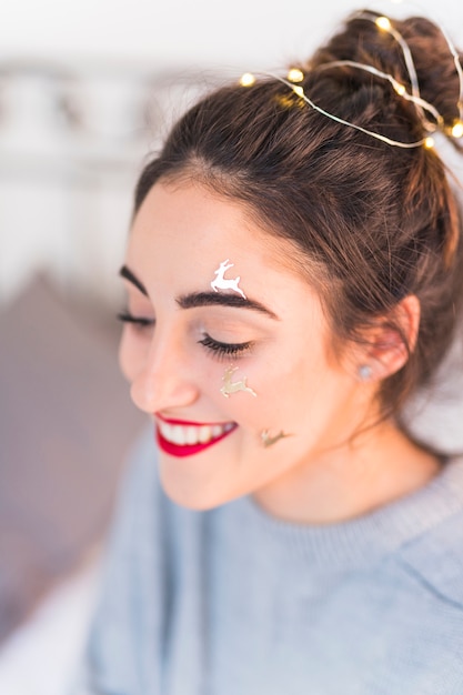 Happy woman with deer spangles on face