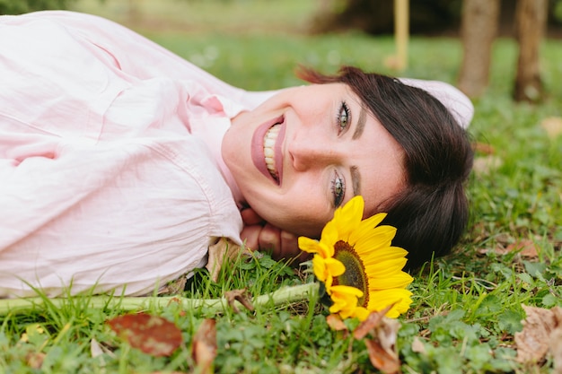 Счастливая женщина с цветком на траве
