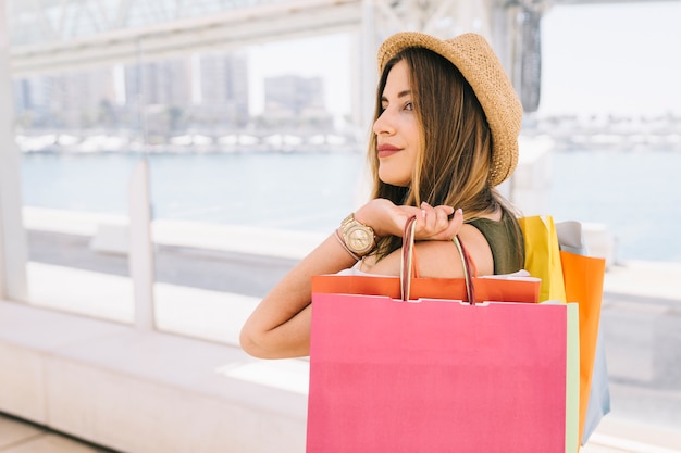 Felice donna con cappello a fare shopping