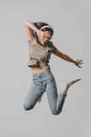 Free photo happy woman with headphones jumping in the air