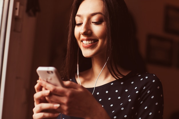 Happy woman with headphones using her phone