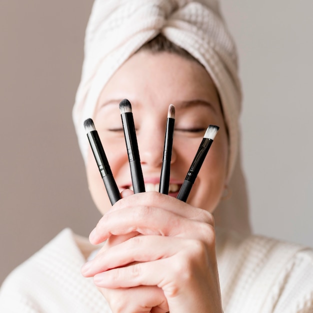 Free photo happy woman with make up brushes