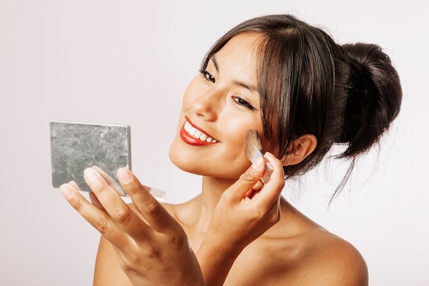 Happy woman with make up and mirror