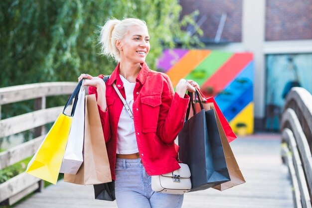 買い物のパケットを持つ幸せな女性