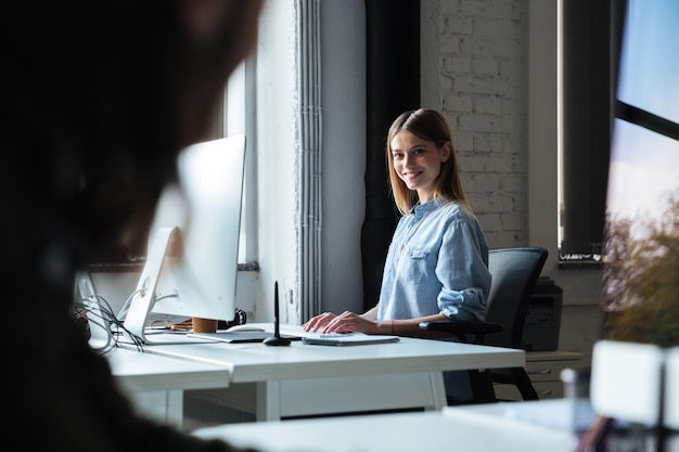 Foto gratuita lavoro felice della donna in ufficio facendo uso del computer