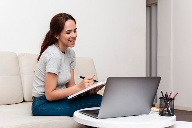 Happy woman working while looking at laptop