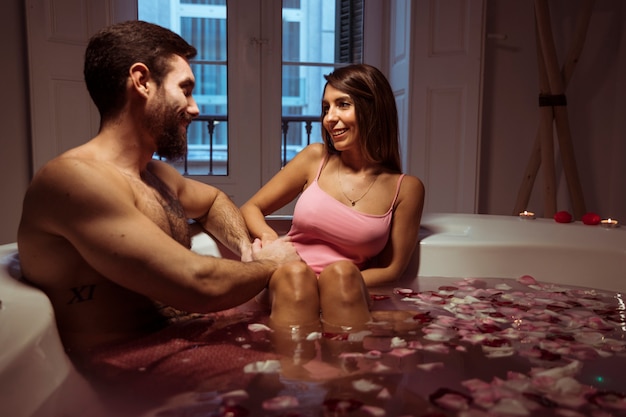 Happy woman and young man in spa tub with water