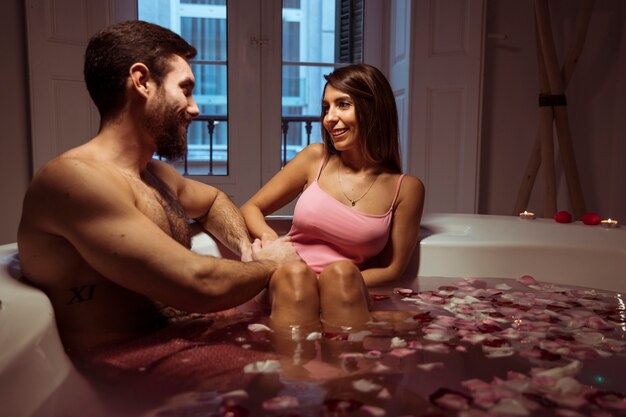 Happy woman and young man in spa tub with water