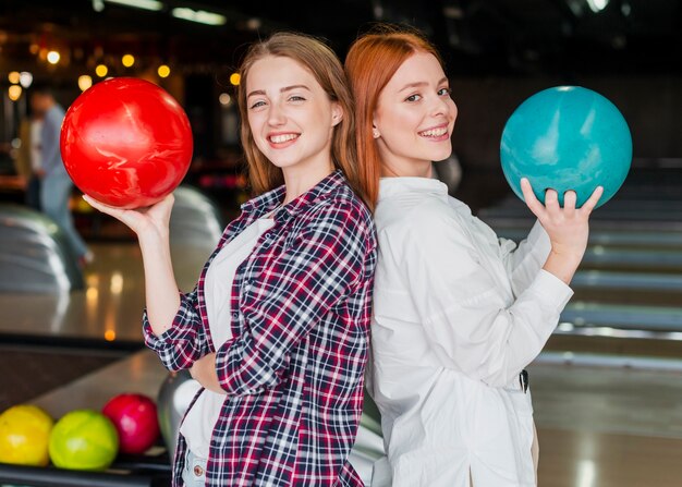 Счастливые женщины, держащие шары для боулинга