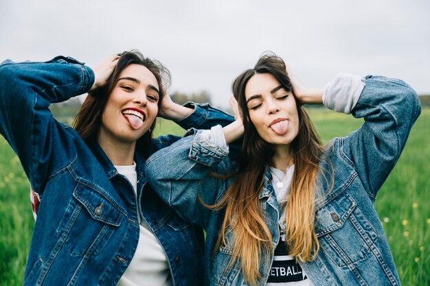 Happy women making grimaces in field