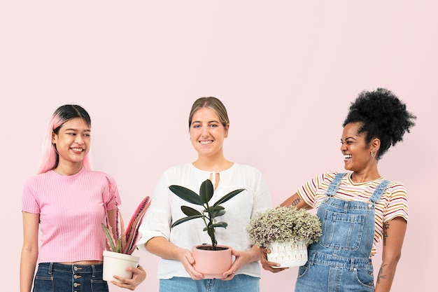 幸せな女性は鉢植えの観葉植物を保持している愛好家を植えます