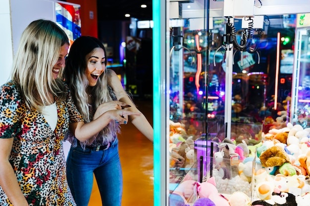 Happy women playing arcade machine