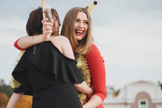 Happy women in red and black dresses partying on the rooftop