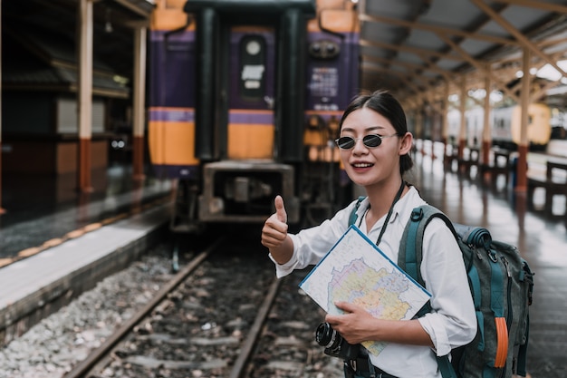 電車、休暇、旅行のアイデアで旅行する幸せな女性。