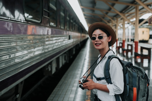 電車、休暇、旅行のアイデアで旅行する幸せな女性。