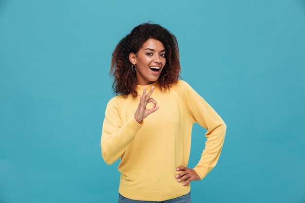 Happy young african lady showing okay gesture.