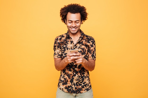 Happy young african man chatting by phone