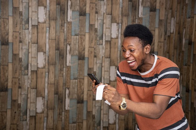 Happy young African man holding a piece of paper