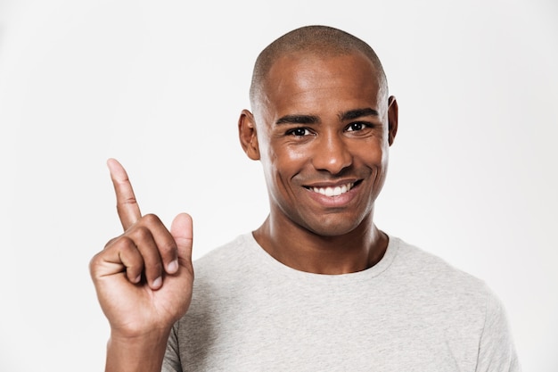 Happy young african man pointing.