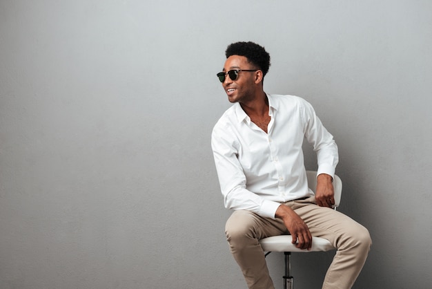 Happy young african man sitting in a chair