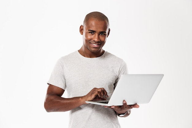 Happy young african man using laptop computer