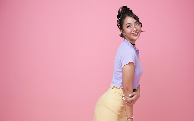 Happy young Asian teenage girl isolated on pink background