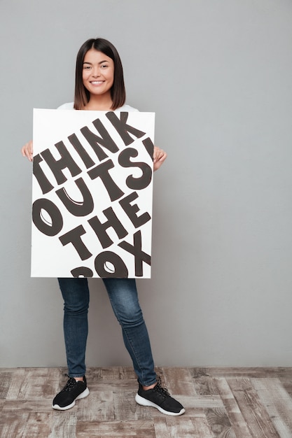 Free photo happy young asian woman holding copyspace blank.