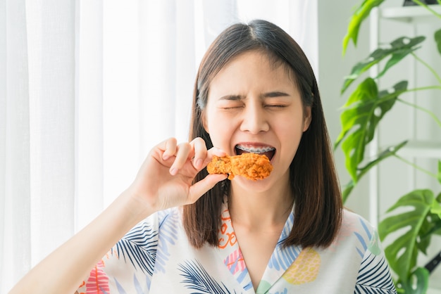 Premium Photo | Happy young asian woman holding fried chicken for eat.