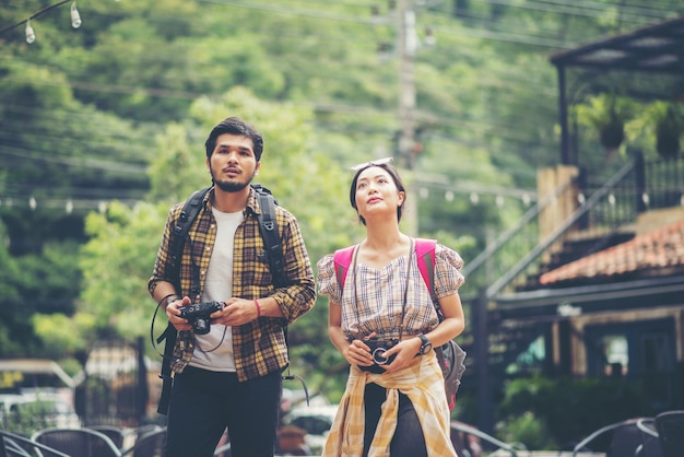 Happy young backpacker couple take a walk together on the street 