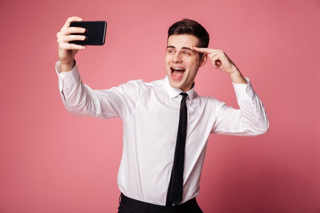 행복 한 젊은 사업가 휴대 전화로 selfie를 확인합니다.