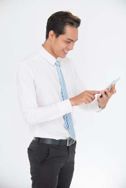 Happy young businessman using digital tablet