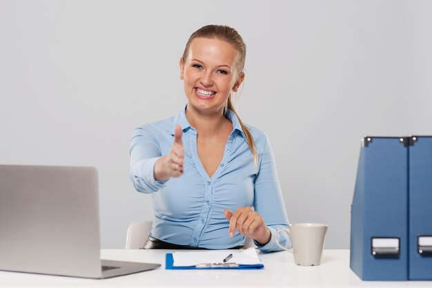 Happy young businesswoman offering handshake