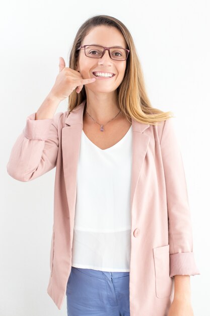 Happy young businesswoman showing call gesture