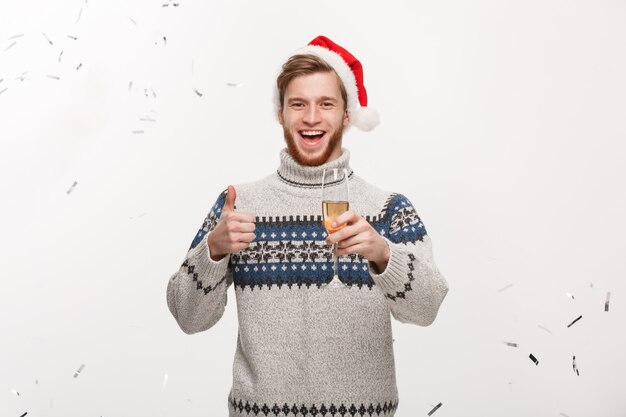 Happy young caucasian beard man holding champagne glass with confetti 