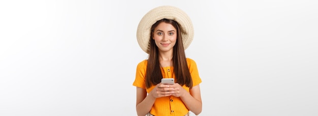 Счастливая молодая кавказская женщина с помощью смартфона, стоящая изолированно на белом