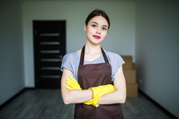 Happy young cleaning lady putting on rubber gloves, getting ready for spring cleaning