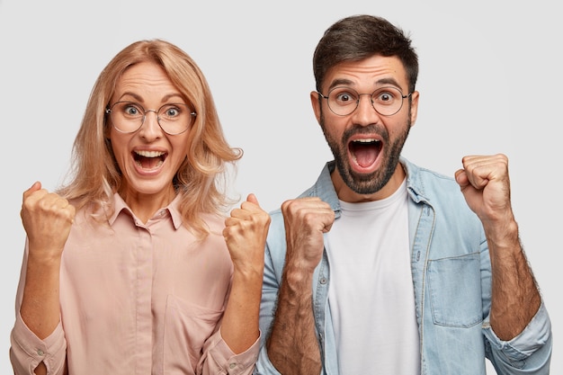 Free Stock Photos: Happy young colleagues or business partners rejoice success, clench fists and exclaim with triumph