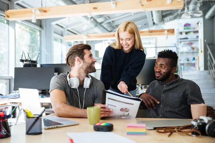 Free Photo happy young colleagues in office coworking