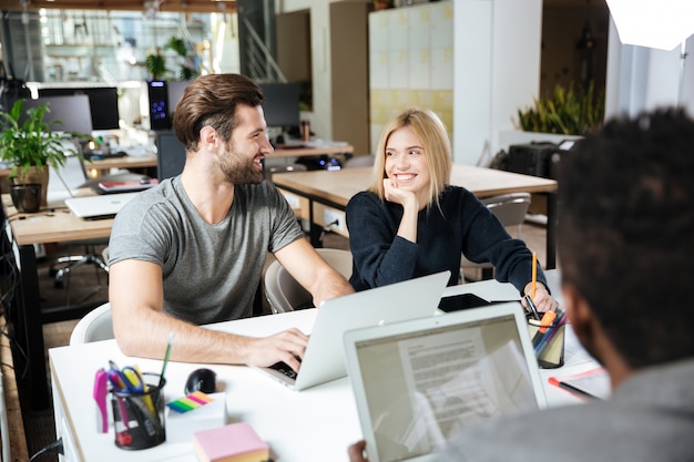 사무실 coworking에 앉아 행복 한 젊은 동료