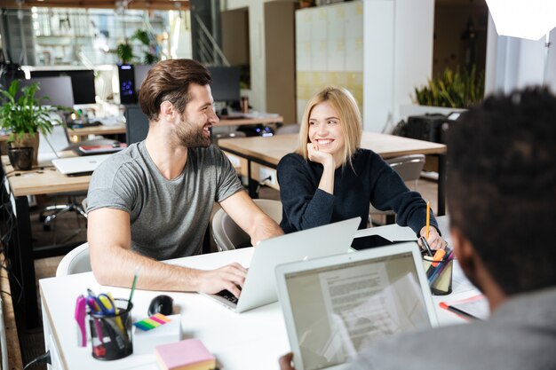 사무실 coworking에 앉아 행복 한 젊은 동료