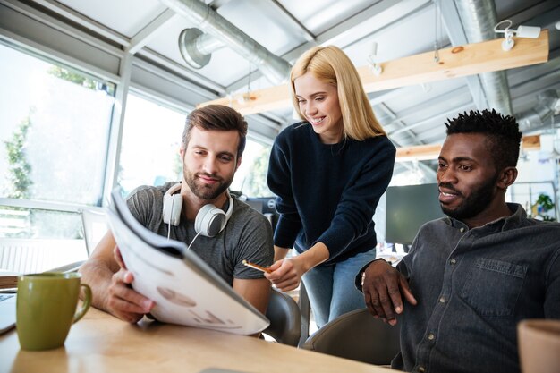 Happy young colleagues talking with each other