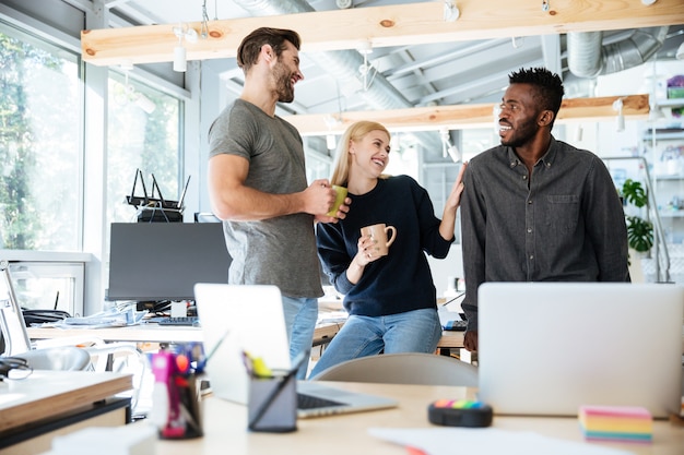 Happy young colleagues talking with each other