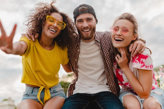 Happy young company of smiling friends excited in park