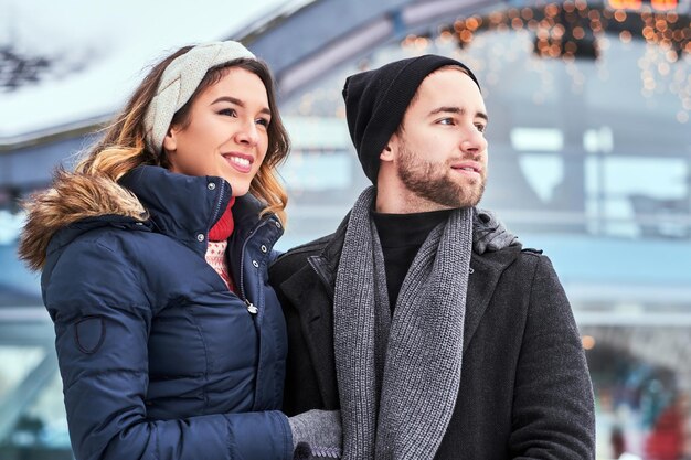 アイススケートリンクでデート、抱き締めて冬時間を楽しんで幸せな若いカップル
