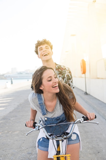 Foto gratuita felice giovane coppia andando per un giro in bicicletta