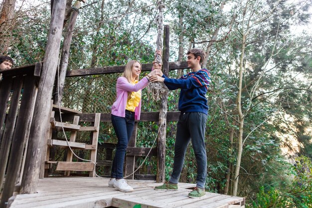 Happy young couple grabbing a rope