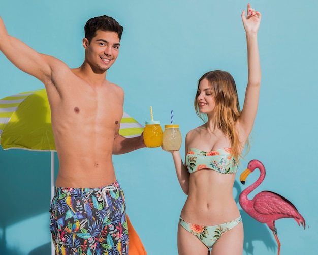 Happy young couple having fun with cocktails in studio